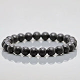 Shungite MSY Mala Bracelet on a reflective grey surface.