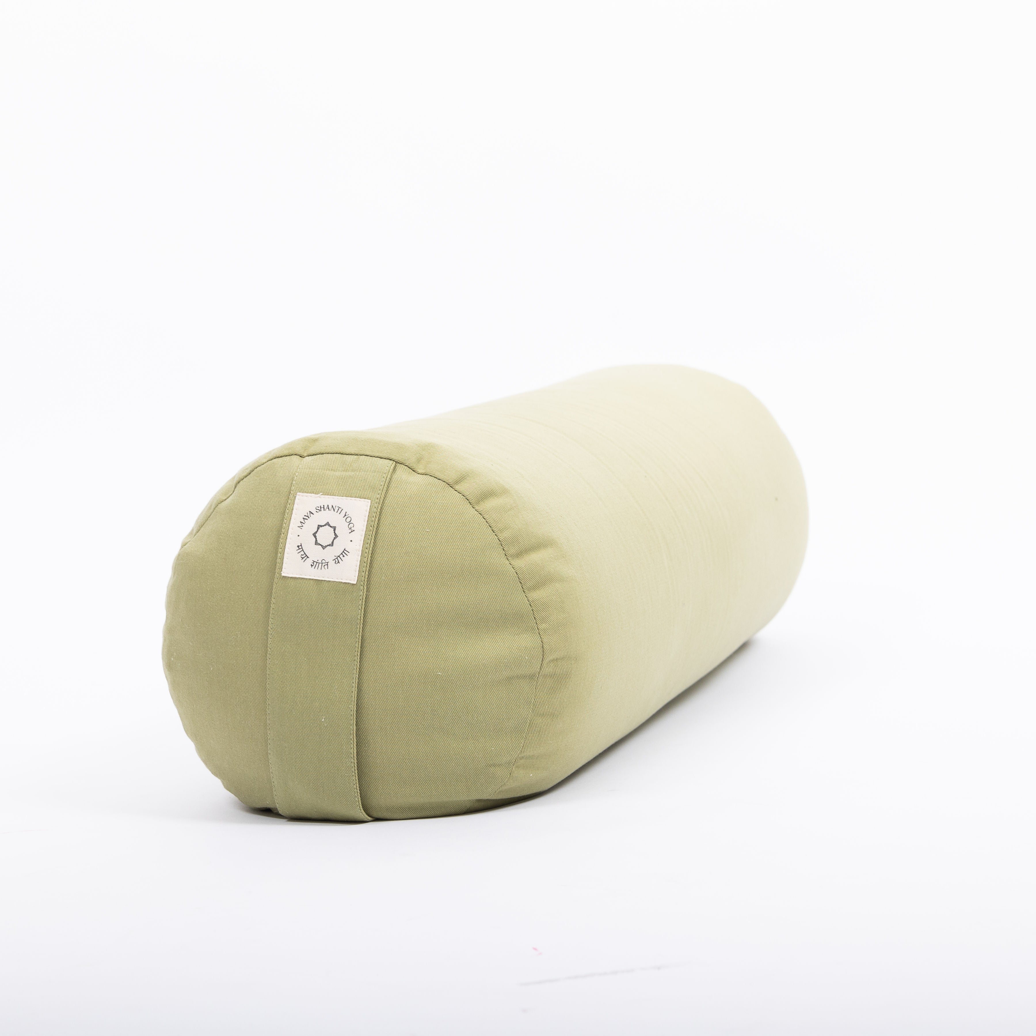 A Maya Shanti Yoga MSY Large Round Buckwheat Bolster in sage green, featuring a small label on one end, sits on a plain white background.