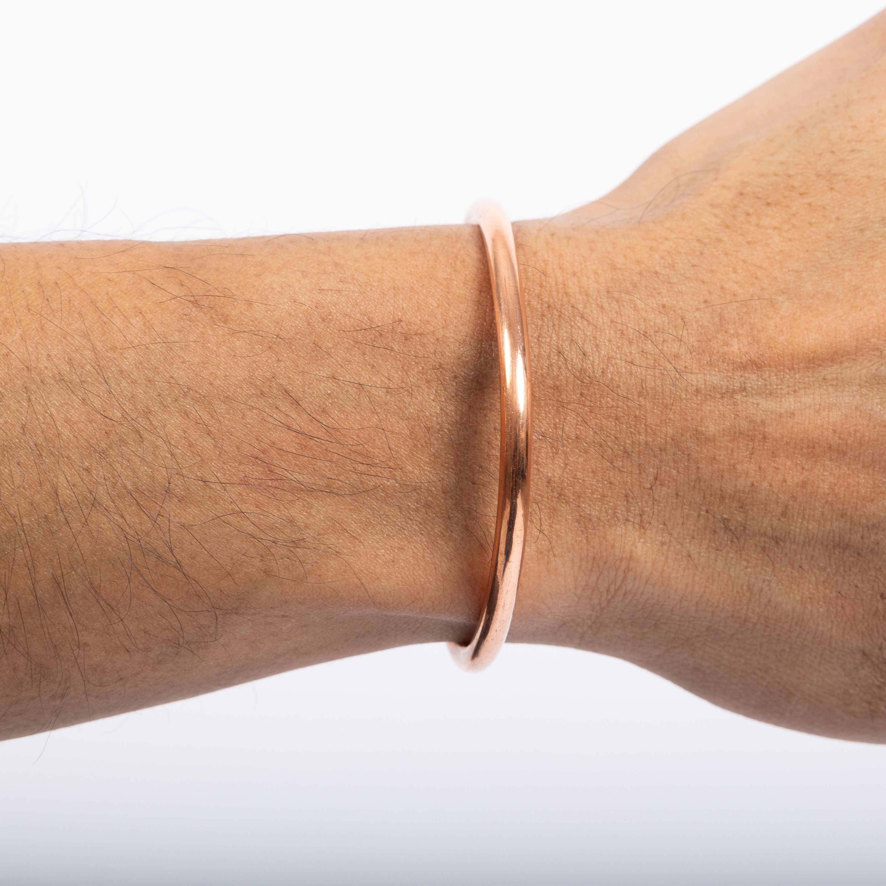 Close-up of a person's wrist wearing a Maya Shanti Copper Bracelet.