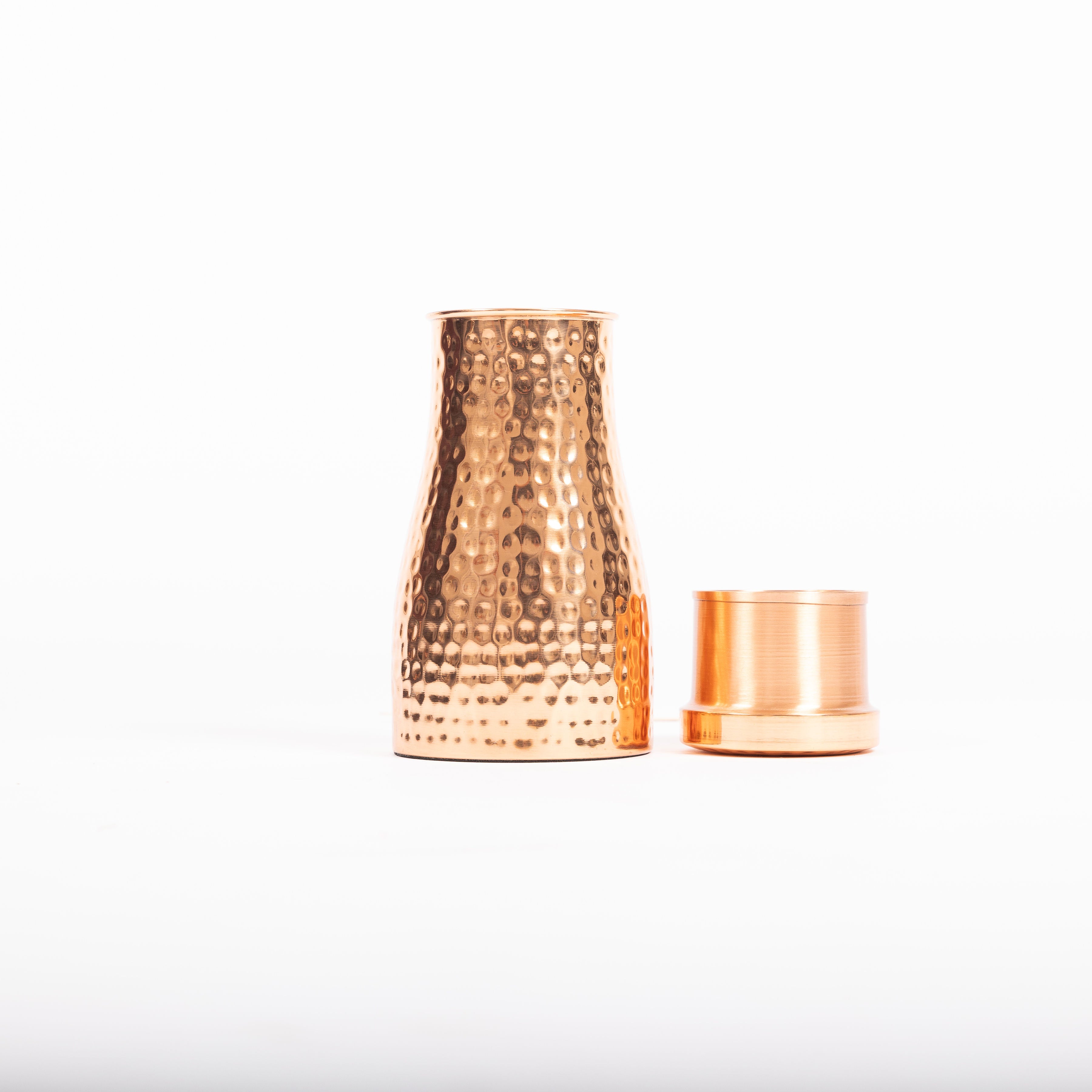 Maya Shanti Yoga 950ml Hammered Copper Carafe beside copper cup on a white background.