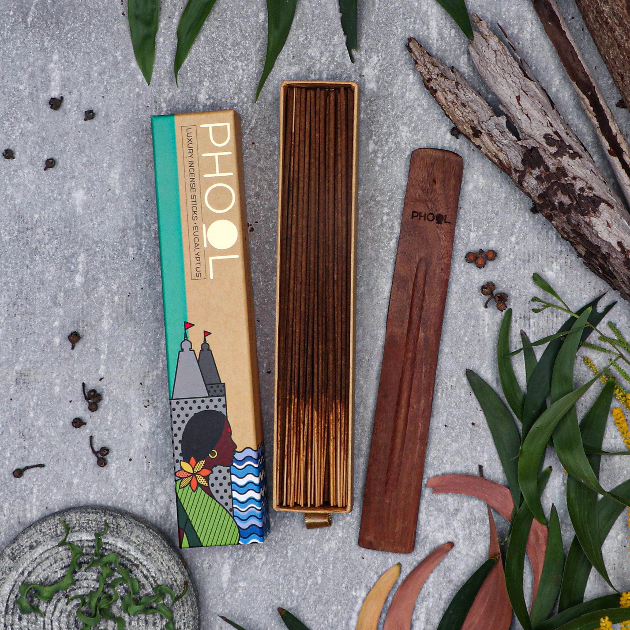 Eucalyptus incense packaging with incense sticks on a textured surface with leaves and spices.