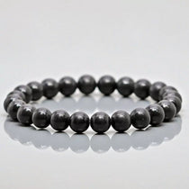 Shungite MSY Mala Bracelet on a reflective grey surface.