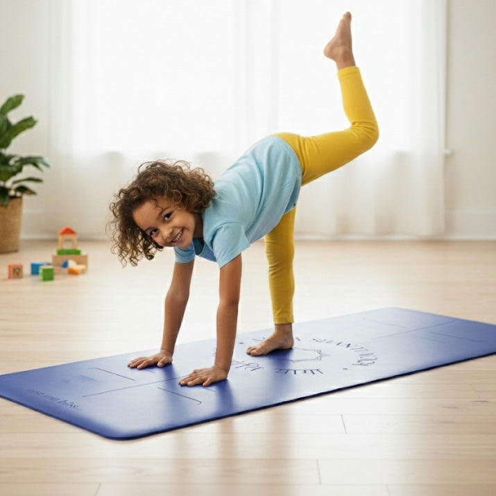 Child in a yoga pose on a blue Maya Shanti Yoga Kids Yoga Mat in a bright room with toys in the background.