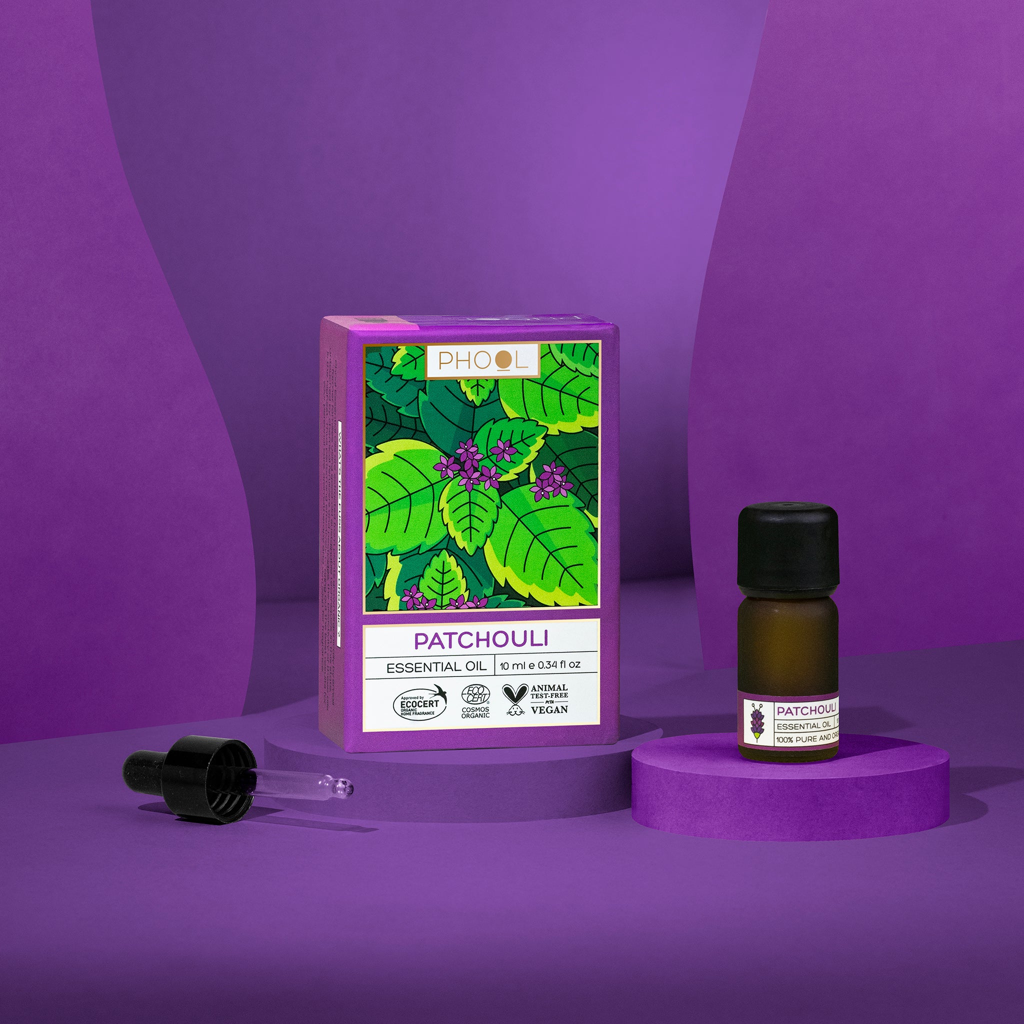 Patchouli essential oil bottle and packaging on a purple background