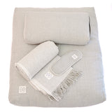 A set of MSY Serenity Bundle including small bolster, zabuton, blanket and eyepillows on a white surface, perfect for mindfulness and meditation, by Maya Shanti Yoga.