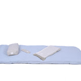 A light blue cushion mat is laid out with a rolled-up gray blanket, a gray eye mask, and a cylindrical gray pillow. There is no detailed product description provided to enhance SEO, but this serene setup promises ultimate comfort and relaxation with the MSY Tranquillity Bundle by Maya Shanti Yoga.