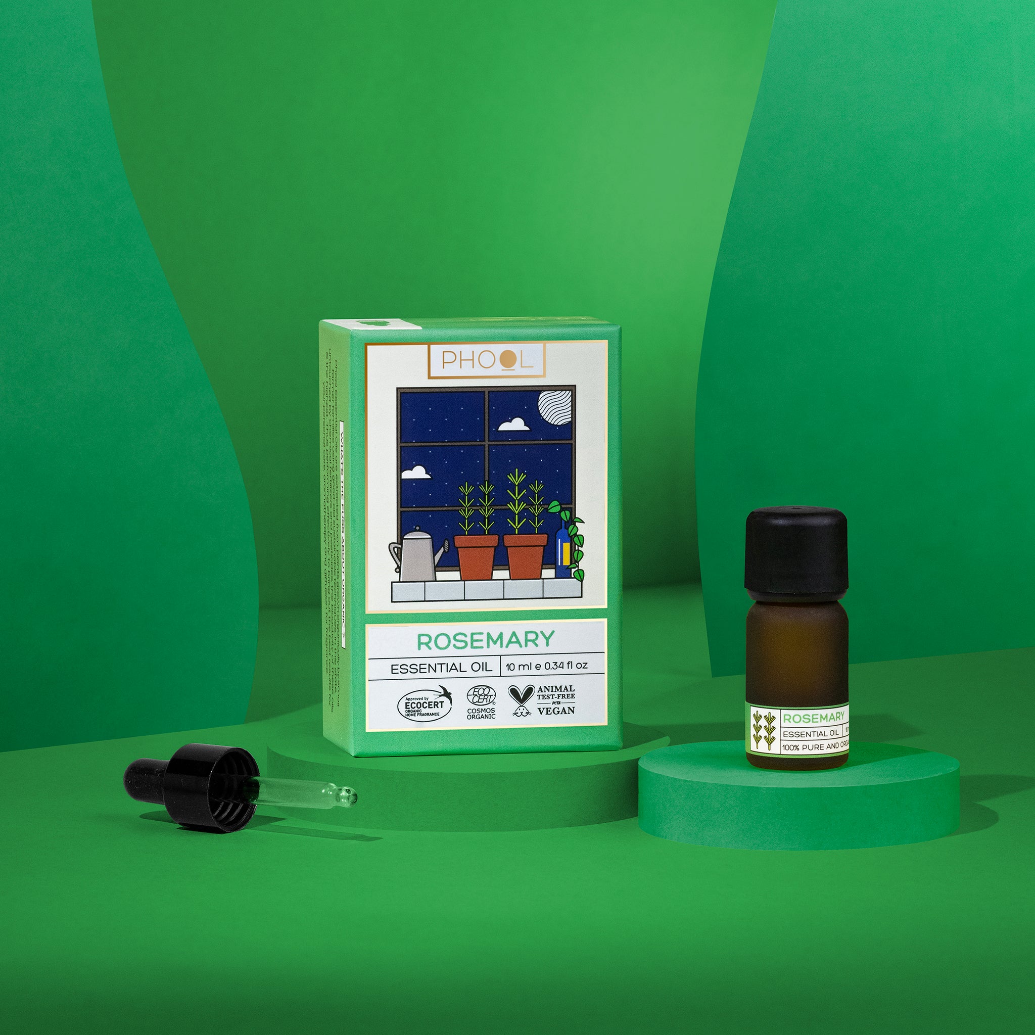 Rosemary essential oil bottle and packaging on a green background