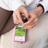 Person holding a bottle of Patchouli essential oil with a matching box.
