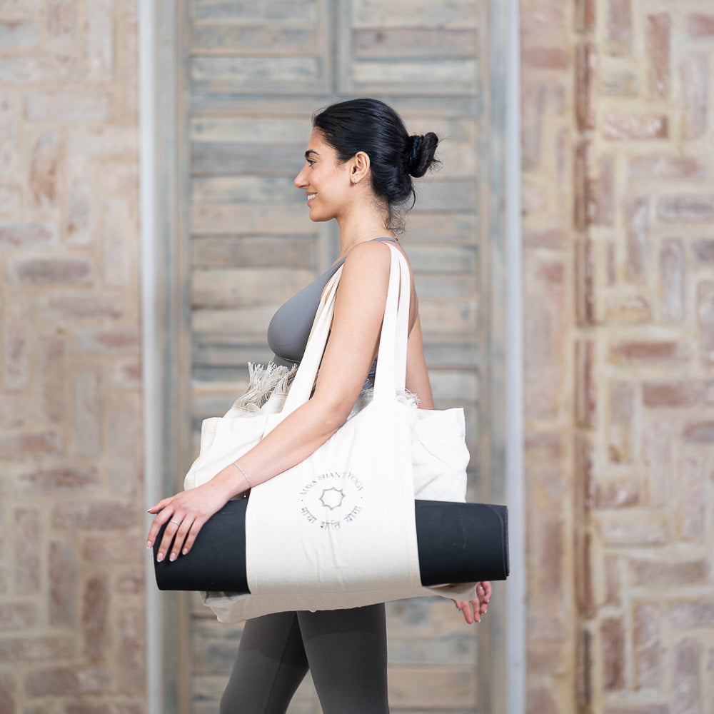 A woman carrying a Maya Shanti Yoga bag with an MSY Meditation Starter Bundle for relaxation.