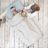 A woman practicing mindfulness and wellness, laying on a MSY Shiatsu Meditation Bed - Organic Cotton from Maya Shanti Yoga with a bowl on her head.