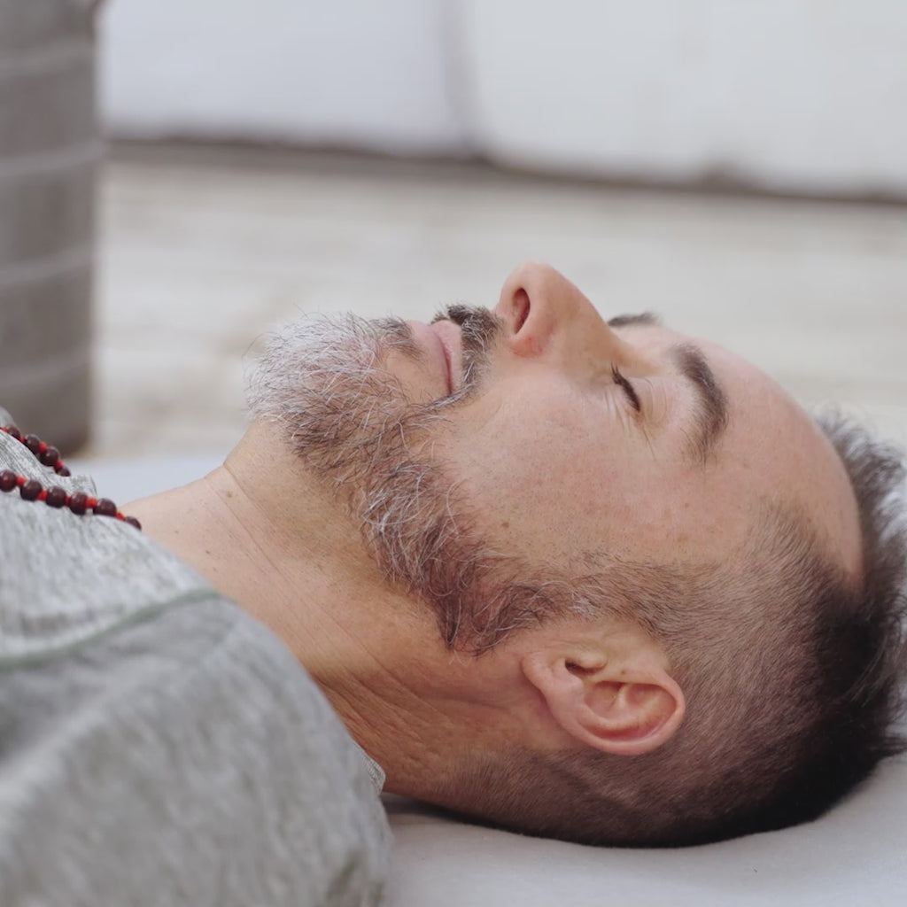 A video of a man using the Maya Shanti Yoga Unwinding Bundle consisting of a Lavender Eye Pillow and a Small Rectangular Bolster, perfect for meditation and relaxation.