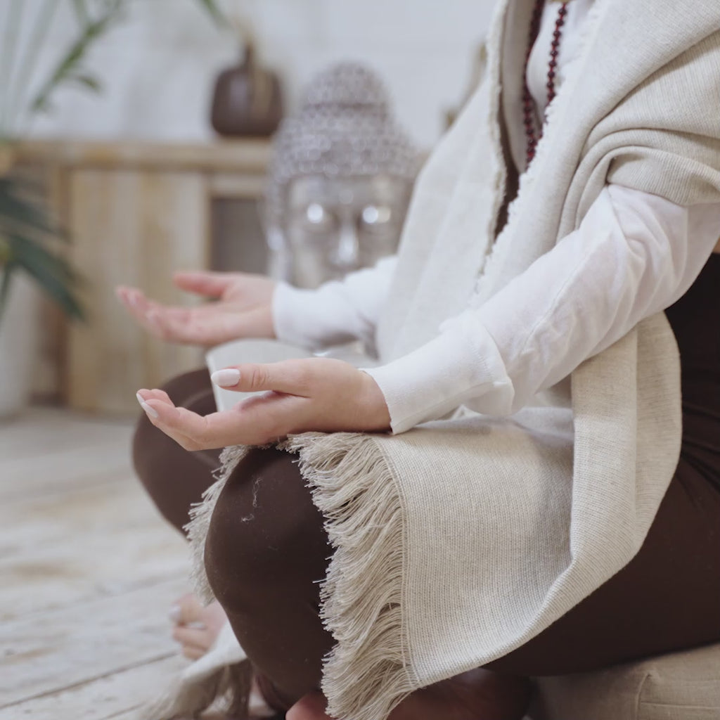 A video of a woman sitting comfortably draped in a MSY Meditation Blanket - Hemp & Organic Cotton.