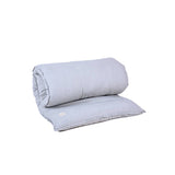 A grey MSY Shiatsu Meditation Bed - Organic Cotton pillow on top of a white background, promoting mindfulness and wellness by Maya Shanti Yoga.